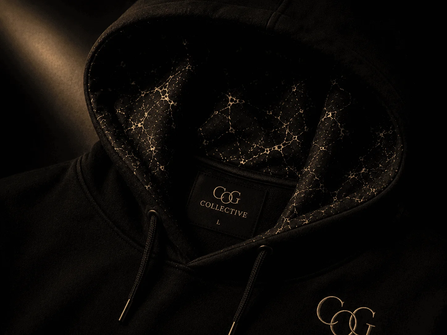 Close-up of the hood lined with gold-veined Identity Marble, with the COG Collective neck label